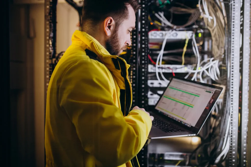 A Man standing in front of a knx smart system with a laptop